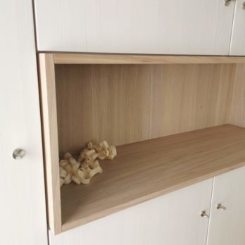 Ein Holzregal mit einer offenen Ablage und Holzspänen im Inneren.