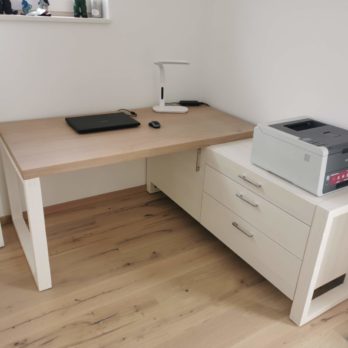 Ein moderner Holztisch mit einem Drucker und einem Schubladenschrank in einem Raum.