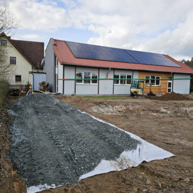 Baustelle mit vorbereiteter Fläche und Schotteruntergrund für den Neubau der Halle.