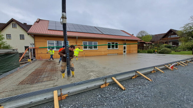 Team beim Betonieren der Bodenplatte – gemeinsamer Einsatz beim Hallenbau.
